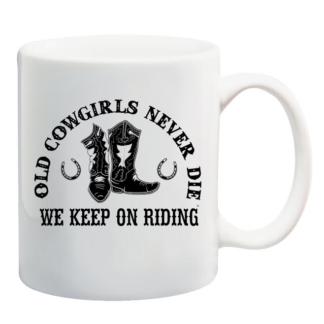 A white mug with the words " old cowgirls never die we keep on riding ".