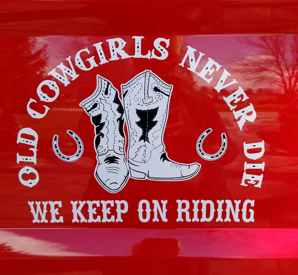 A red truck with the words " old cowgirls never die we keep on riding ".